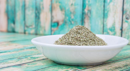 Dried oregano herbs in white bowl over wooden backgroundの写真素材