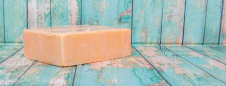A block of cheddar cheese over wooden backgroundの写真素材