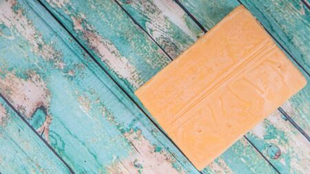 A block of cheddar cheese over wooden backgroundの写真素材