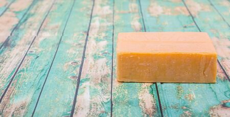 A block of cheddar cheese over wooden backgroundの写真素材