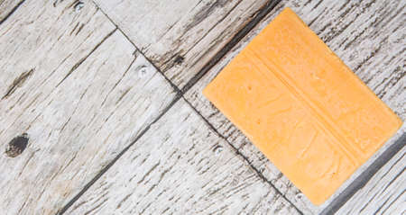 A block of cheddar cheese over wooden backgroundの写真素材