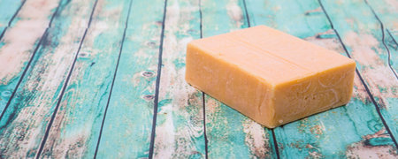 A block of cheddar cheese over wooden background