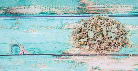 Dried linden flower herbal tea over wooden background