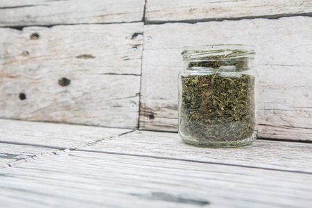 Dried Japanese green tea leaves in a mason jar over wooden backgroundの写真素材