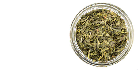 Dried Japanese green tea leaves in mason jar over white backgroundの写真素材