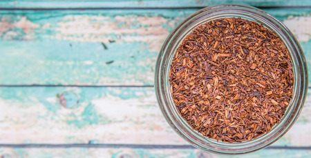 Dried rooibos herbal tea in mason jar over wooden backgroundの写真素材