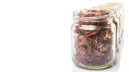 Dried herbal tea lavender, chamomile, linden flower, rooibos, hibiscus, Japanese green tea in mason jars over white backgroundの写真素材