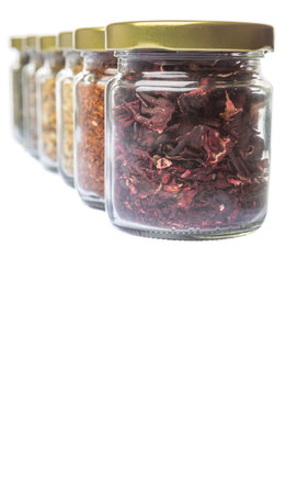 Dried herbal tea lavender, chamomile, linden flower, rooibos, hibiscus, Japanese green tea in mason jars over white backgroundの写真素材