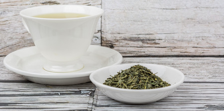 Japanese green tea in white cup over wooden backgroundの写真素材