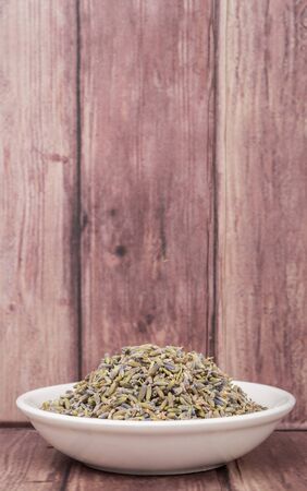 Dried lavender herbal tea in white bowl over wooden backgroundの写真素材