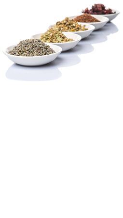 Dried herbal tea leaves, lavender, rooibos, chamomile, linden flower, hibiscus, Japanese green tea in white bowl over white backgroundの写真素材