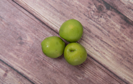 Pickled olive fruit over wooden backgroundの写真素材