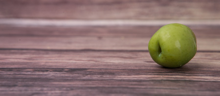 Pickled olive fruit over wooden backgroundの写真素材