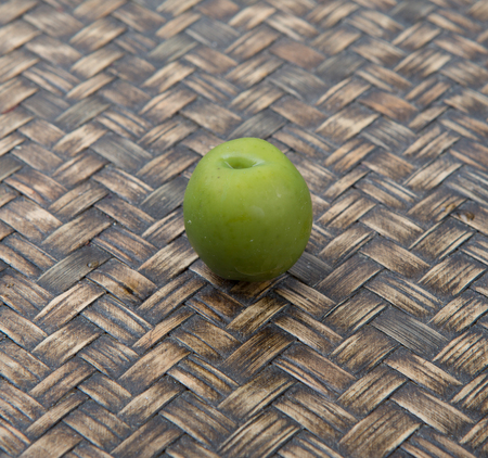 Pickled olive fruit over wooden backgroundの写真素材