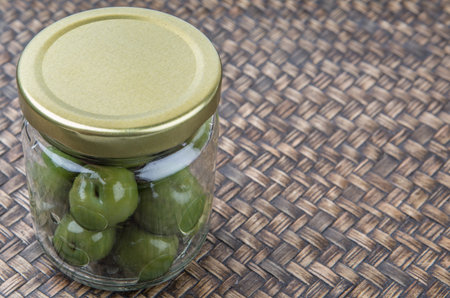 Pickled green olives fruit over wooden backgroundの写真素材