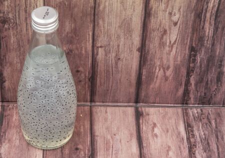 Sweet basil seed drink in a bottle over wooden backgroundの写真素材