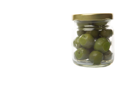 Pickled green olive fruit in mason jar over white backgroundの写真素材