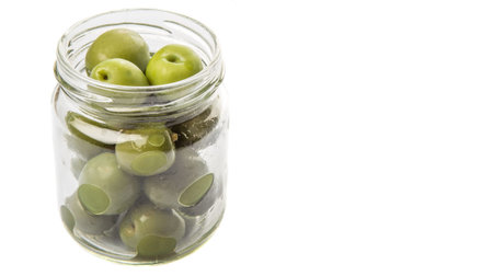 Pickled green olive fruit in mason jar over white backgroundの写真素材