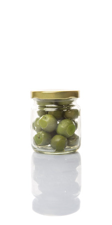 Pickled green olive fruit in mason jar over white backgroundの写真素材