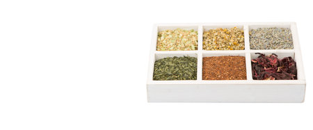 Dried herbal tea leaves, lavender, rooibos, chamomile, linden flower, hibiscus, Japanese green tea in white wooden box over white backgroundの写真素材