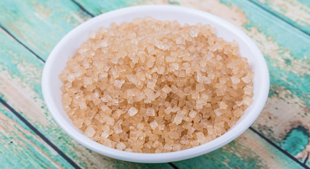 Brown sugar in white bowl over wooden backgroundの写真素材