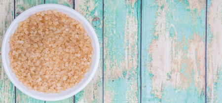 Brown sugar in white bowl over wooden backgroundの写真素材