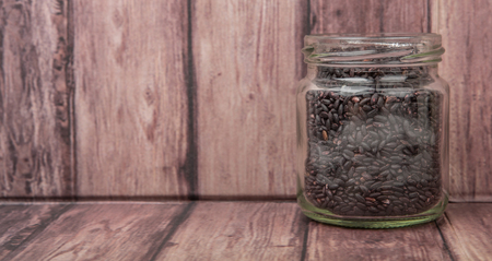 Black millet in mason jars over wooden backgroundの写真素材