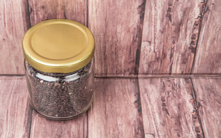 Black millet in mason jars over wooden backgroundの写真素材