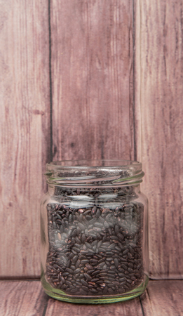 Black millet in mason jars over wooden backgroundの写真素材