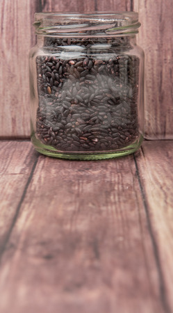 Black millet in mason jars over wooden backgroundの写真素材