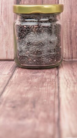 Black millet in mason jars over wooden backgroundの写真素材