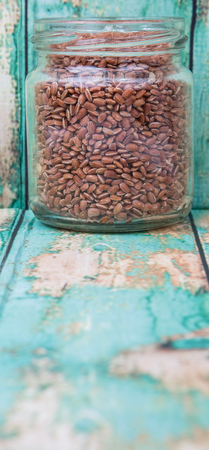Brown millet grain seed in a mason jar over wooden backgroundの写真素材