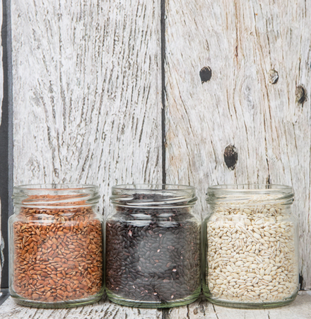 White, brown, black millet in mason jars over wooden backgroundの写真素材