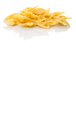Dried italian bowtie pasta or farfalle over white backgroundの写真素材