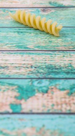 Dried corkscrew shape pasta or rotini pasta over wooden backgroundの写真素材