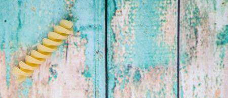 Dried corkscrew shape pasta or rotini pasta over wooden backgroundの写真素材