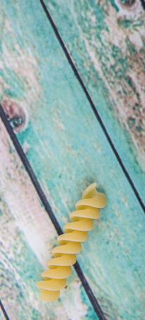 Dried corkscrew shape pasta or rotini pasta over wooden backgroundの写真素材