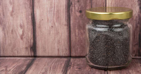 Black sesame seed in mason jar over wooden backgroundの写真素材