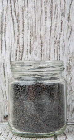 Black sesame seed in mason jar over wooden backgroundの写真素材