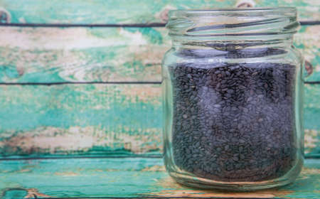 Black sesame seed in mason jar over wooden backgroundの写真素材