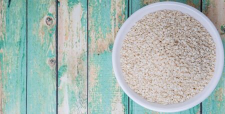 White sesame seed in white bowl over wooden backgroundの写真素材