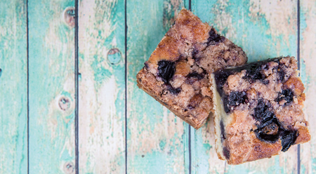 Portions of delicious homemade blueberry sponge cakes over wooden background