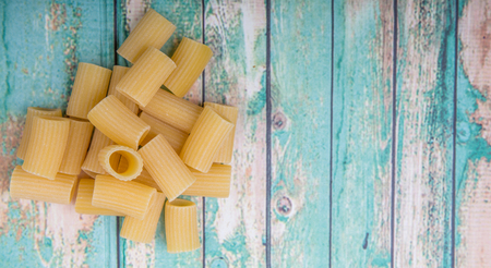 Rigatoni pasta or tube shaped pasta over wooden backgroundの写真素材