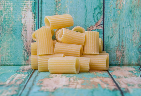 Rigatoni pasta or tube shaped pasta over wooden backgroundの写真素材