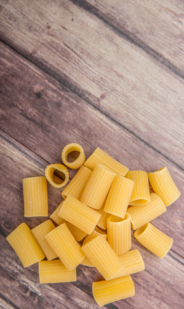 Rigatoni pasta or tube shaped pasta over wooden backgroundの写真素材