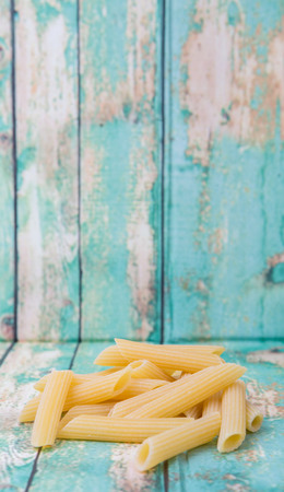 Dried penne regate pasta over wooden backgroundの写真素材