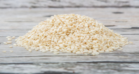 White sesame seed over wooden background