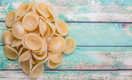 Dried orecchiatte pasta or ear shaped pasta over woodの写真素材