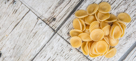 Dried orecchiatte pasta or ear shaped pasta over wooden backgroundの写真素材