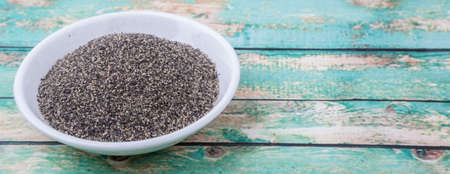 Black pepper powder in white bowl over wooden backgroundの写真素材